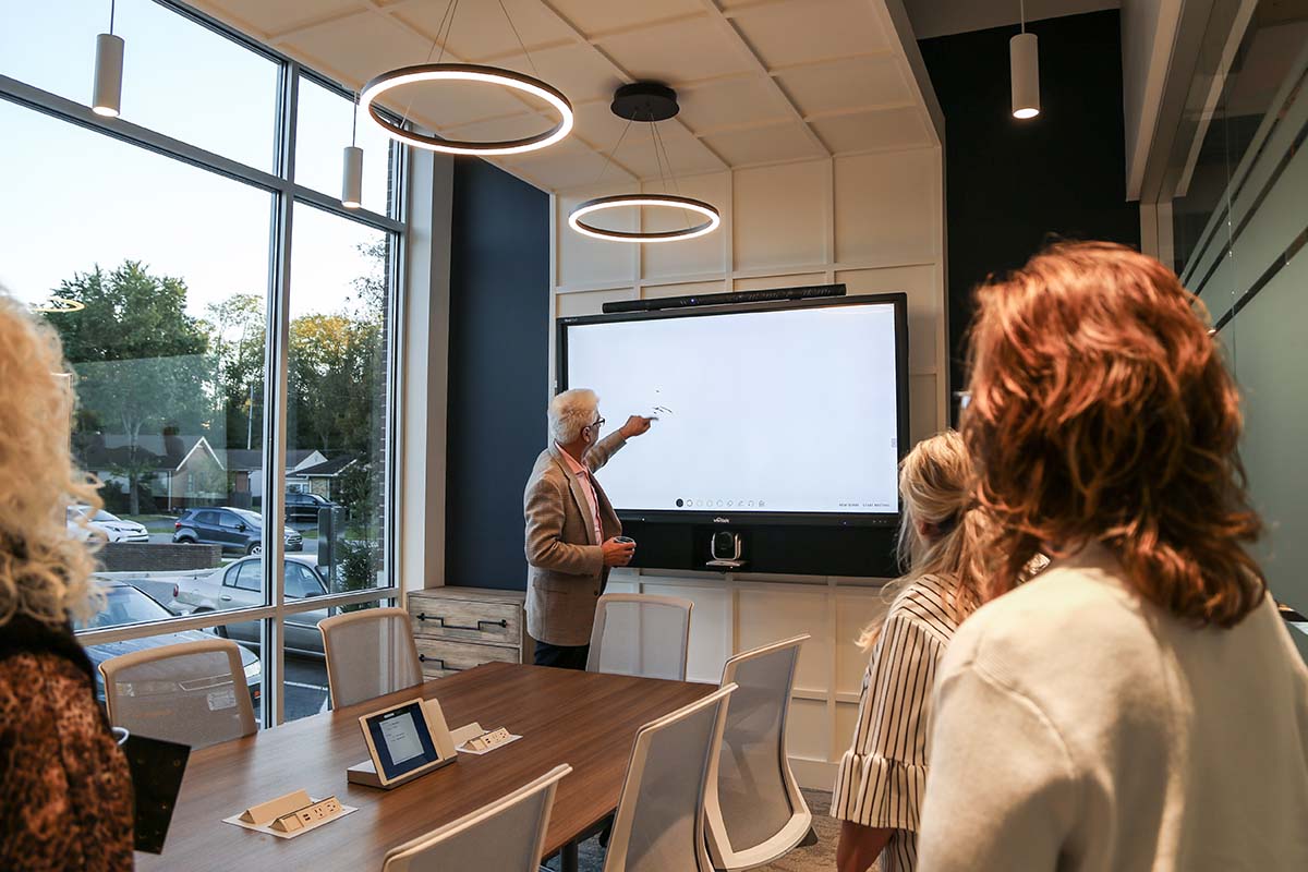 Person presenting in a conference room using a smart TV